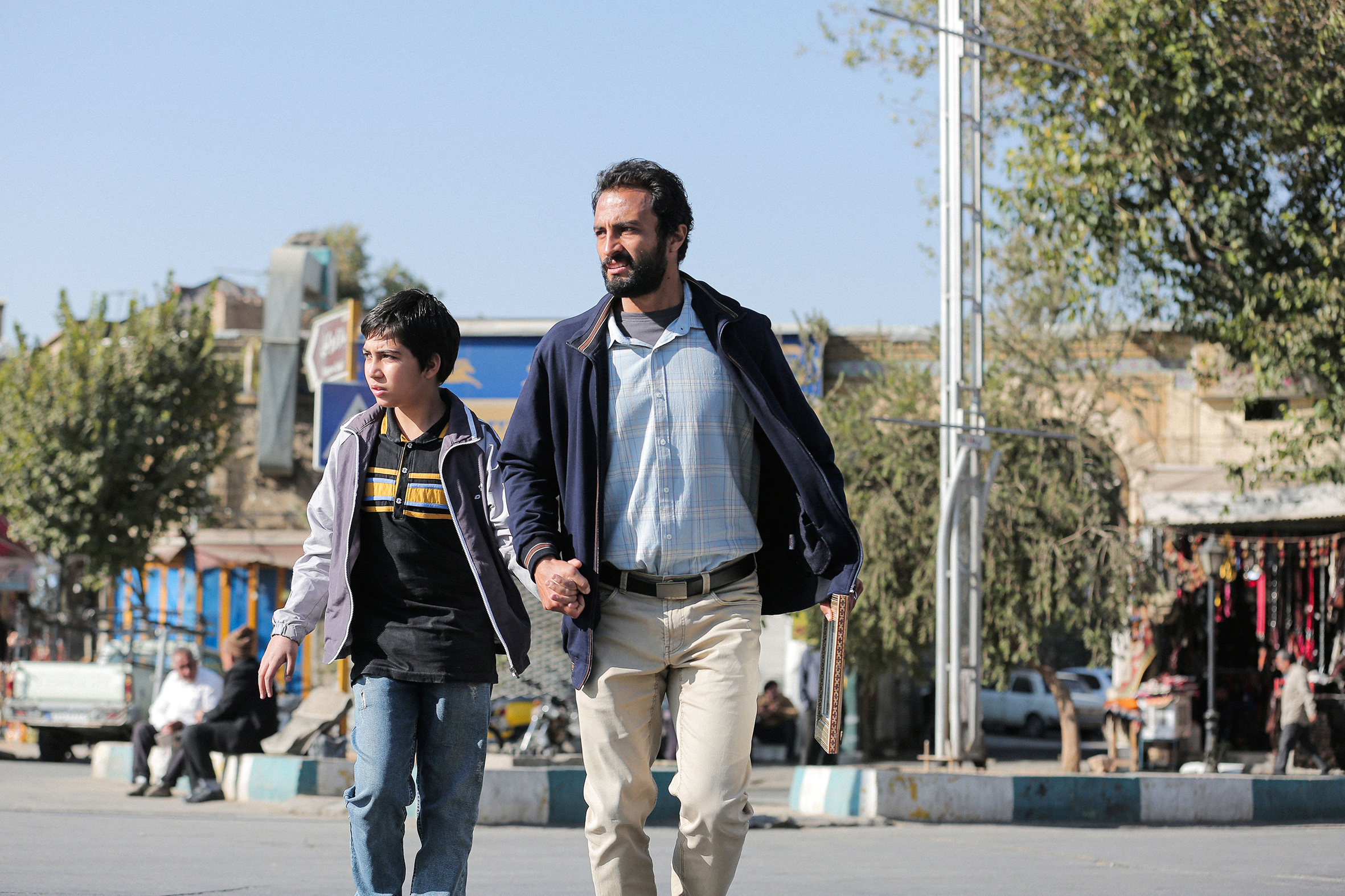 Rahim Soltani and his son walking at the street A hero